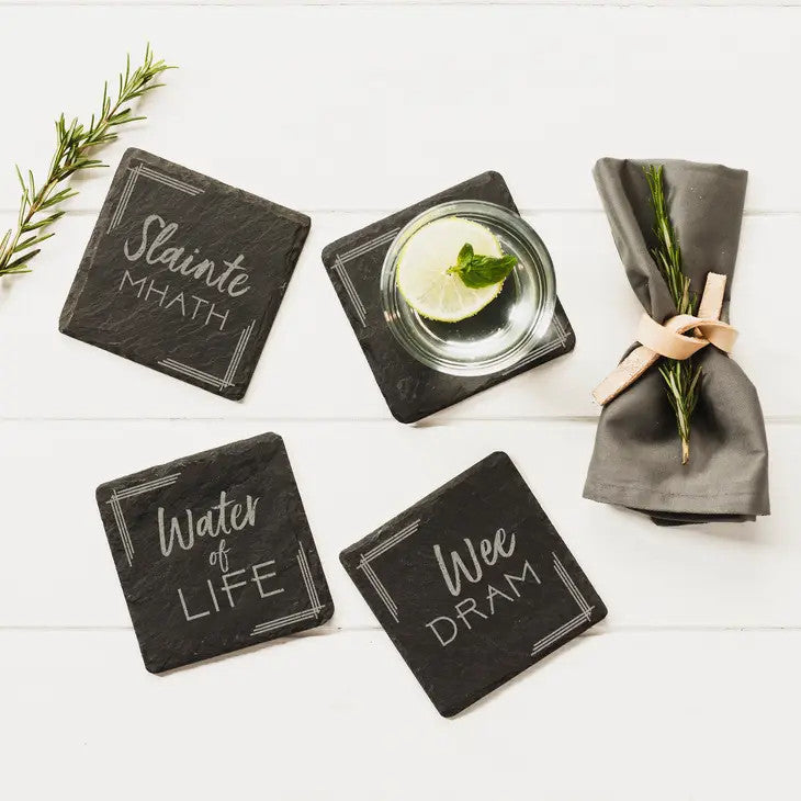 Whisky set of 4 slate coasters with each coaster featuring a different design: "A Wee Dram", "Slainte Mhath", "The Angels Share" and "Water of Life" by Selbrae House. 